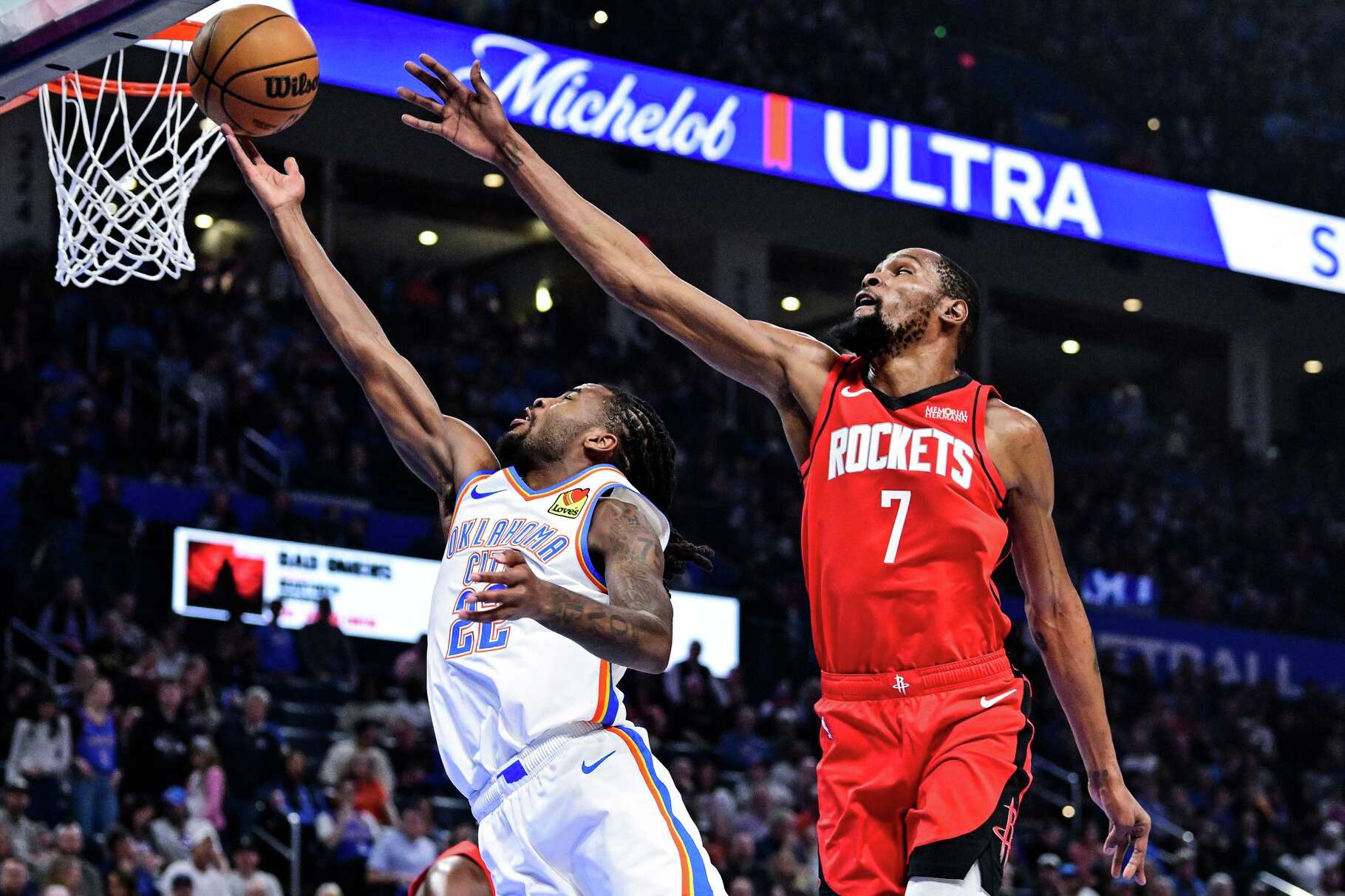 Oklahoma City Thunder guard Cason Wallace (22) shoots against Houston Rockets forward Kevin Durant (7) during the first half of an NBA basketball game Saturday, Feb. 7, 2026, in Oklahoma City. (AP Photo/Gerald Leong)