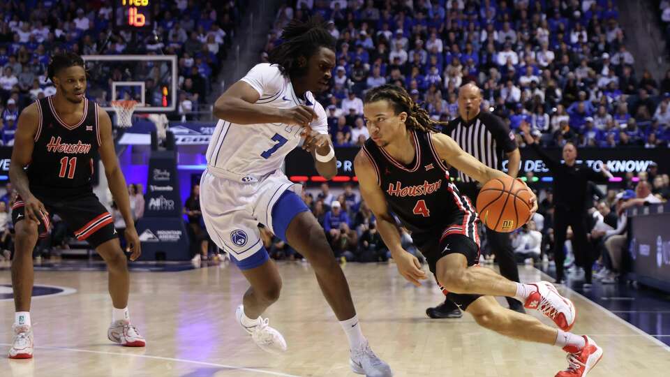 Houston guard Kingston Flemings (4) drives to the basket as BYU forward Khadim Mboup (7) defends during the second half of an NCAA college basketball game, Saturday, Feb. 7, 2026, in Provo, Utah. (AP Photo/Rob Gray)