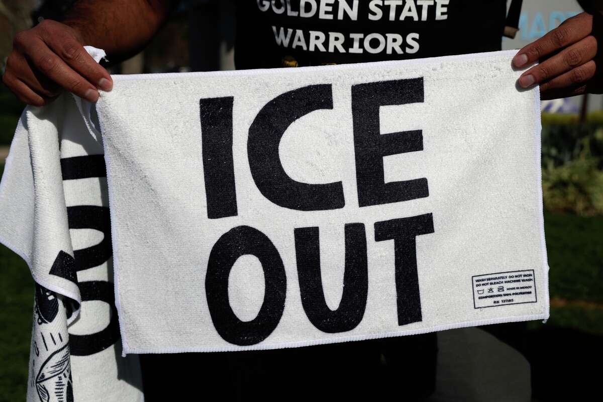 Contra-ICE volunteer Gilbert Lopez hands out rally towels to fans as they make their way to Levi's Stadium Super Bowl LX between the Seattle Seahawks and New England Patriots, Sunday, Feb. 8, 2026, in Santa Clara, Calif. (Brontë Wittpenn/San Francisco Chronicle via AP)