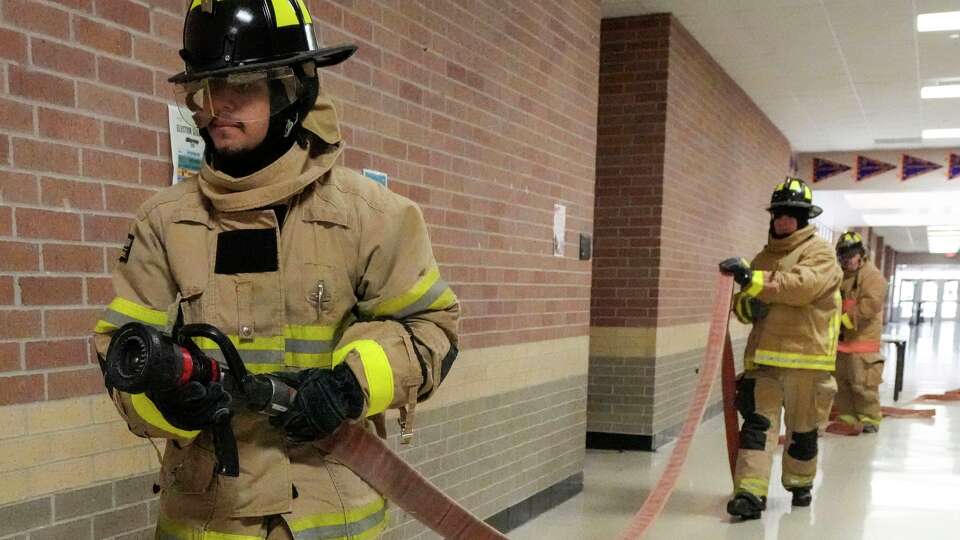 Abram Diaz, Derian Villacorta, and Anthony Sosa run through a firefighting drill in a Fire/EMS class at HISD’s Cesar E. Chavez High School in Houston, Tuesday, Feb. 10, 2026. The Houston Independent School District high school offers a program for students interested in becoming firefighters, EMTs, or emergency dispatchers and the medical field. Through its Career and Technical Education programs, the district equips students with real-world skills and industry certifications that prepare them for potential careers in these fields.