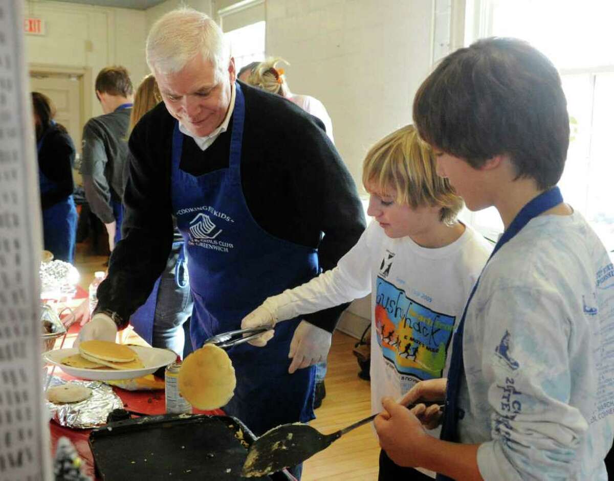From left, Brad Hart, Dayton Kingery, 12, and Grant Quackenbush, 13, all of Greenwich, work the grill during the Boys & Girls Club of Greenwich pancake breakfast with Santa at the club Saturday morning, Dec. 11, 2010.