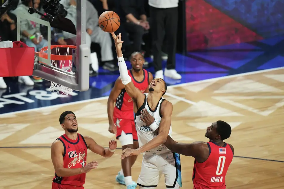World center Victor Wembanyama, of France, shoots over USA Stars guard Devin Booker, left, and forward Jalen Duren during the NBA All-Star basketball game Sunday, Feb. 15, 2026, in Inglewood, Calif. (AP Photo/Jae C. Hong)