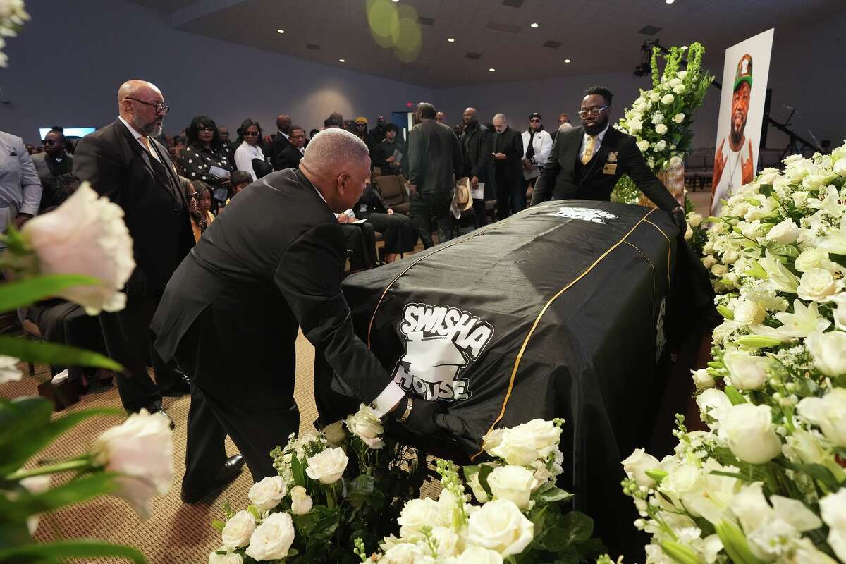 Ushers prepare to move the casket with the body of Michael