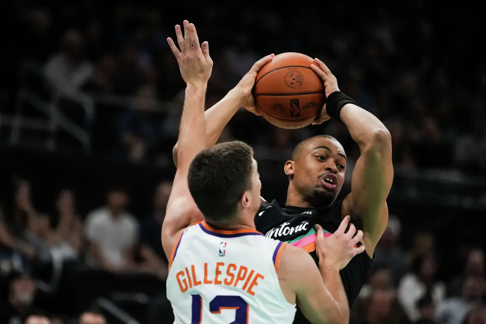 San Antonio Spurs guard Keldon Johnson (3) keeps the ball away from defense by Phoenix Suns guard Collin Gillespie (12) in the first quarter as the Spurs take on the Suns on Thursday night, Feb. 19, 2026 in the first of two “I-35 Series” games in Austin at the Moody Center.