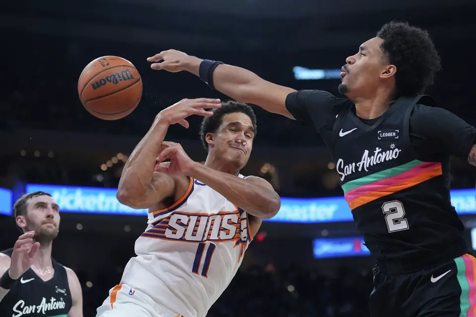 San Antonio Spurs guard Dylan Harper (2) knocks the ball away from Phoenix Suns forward Oso Ighodaro (11) during the first half of an NBA basketball game in Austin, Texas, Thursday, Feb. 19, 2026.