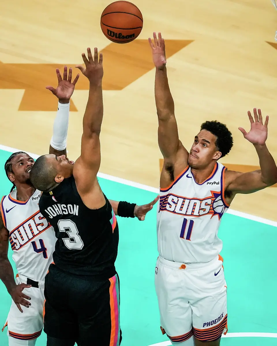 San Antonio Spurs guard Keldon Johnson (3) puts the ball up as Phoenix Suns guard Jalen Green (4) and forward Oso Ighodaro (11) defend in the third quarter as the Spurs take on the Suns on Thursday night, Feb. 19, 2026 in the first of two “I-35 Series” games in Austin at the Moody Center. The Spurs won the game 121-94.