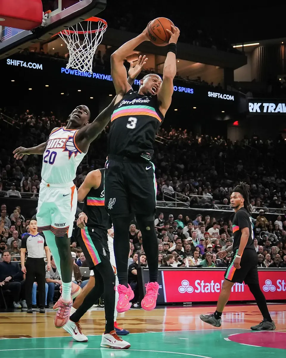 San Antonio Spurs forward/guard Keldon Johnson (3) grabs the defensive rebound over Phoenix Suns forward Rasheer Fleming (20) in the fourth quarter as the Spurs take on the Suns on Thursday night, Feb. 19, 2026 in the first of two “I-35 Series” games in Austin at the Moody Center. The Spurs won the game 121-94.