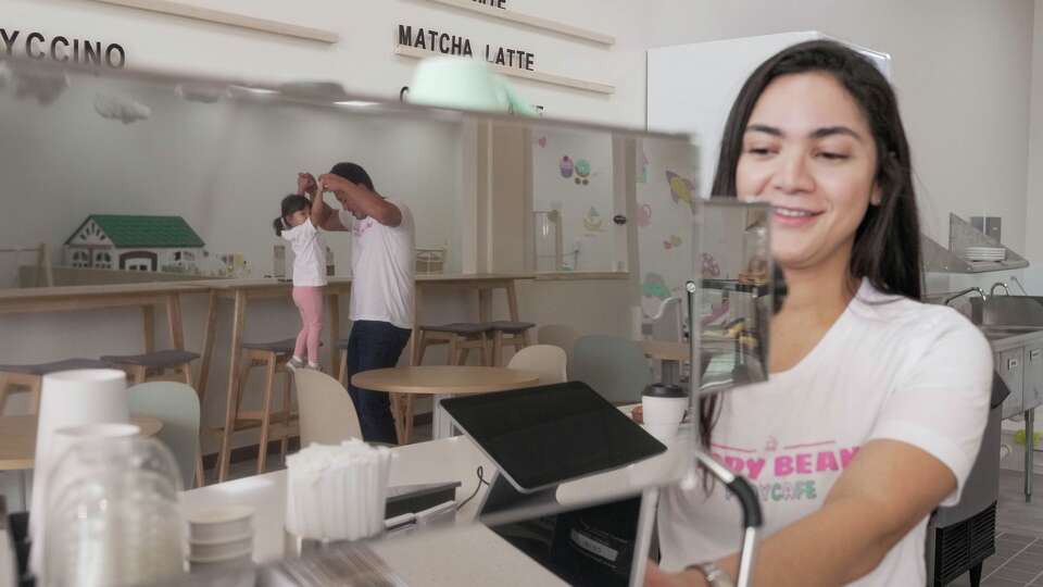 Vitoria Gomes Won makes coffee while David Won and their daughter Olivia Won, 2, play in the background at Happy Beans Play Cafe in Houston on Thursday, Feb. 19, 2026.