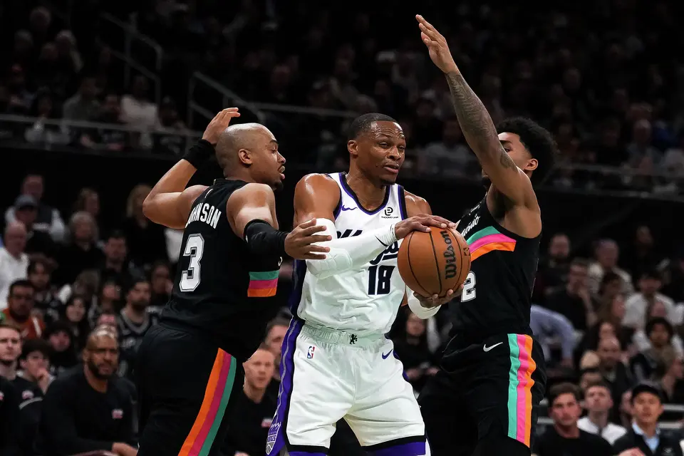 Sacramento Kings guard Russell Westbrook (18) is guarded by San Antonio Spurs guards Dylan Harper (2) and Keldon Johnson (3) during the game at the Moody Center on Saturday, Feb. 21, 2026 in Austin.