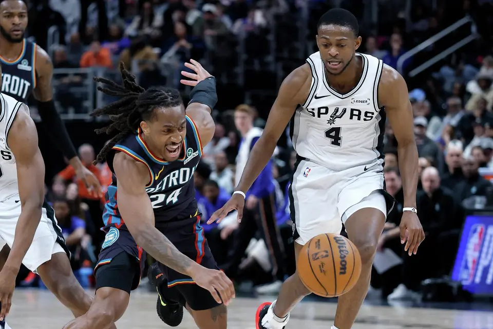 Detroit Pistons guard Daniss Jenkins (24) loses control of the ball after being fouled by San Antonio Spurs guard De'aaron Fox (4) during the second half of an NBA basketball game Monday, Feb. 23, 2026, in Detroit. (AP Photo/Duane Burleson)
