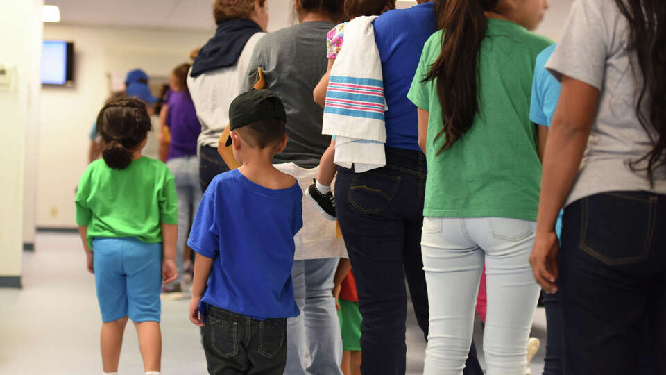 In this 2018 file photo, provided by U.S. Immigration and Customs Enforcement, mothers and their children stand in line at South Texas Family Residential Center in Dilley. 