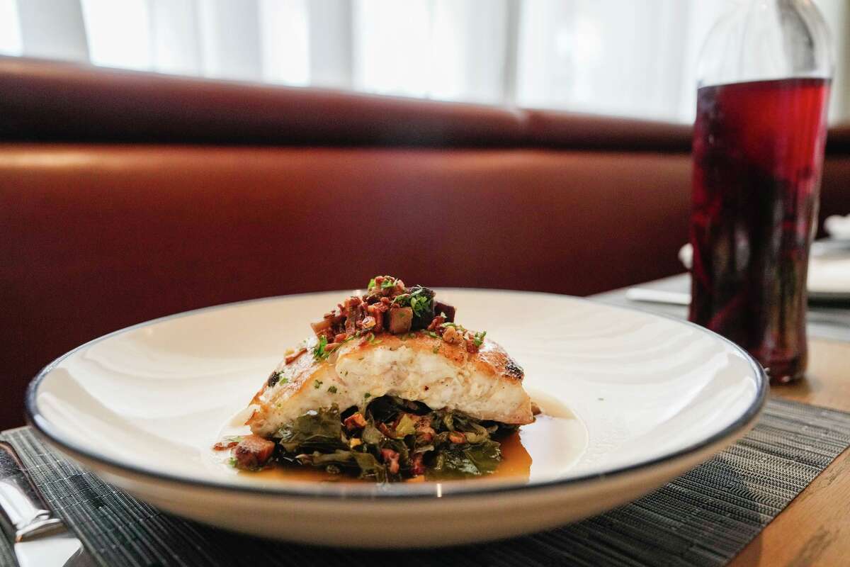 Grouper à la plancha with braised collard greens, potlikker jus and pork cracklin is photographed in Houston, Tuesday, Feb. 24, 2026.