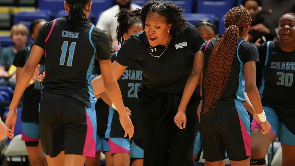 Shadow Creek head coach LaToya Micheaux gives players high-fives as a timeout is called during the second half of a Class 6A-Division II Region III semifinal girls basketball playoff game in Cypress, Tuesday, Feb. 24, 2026.