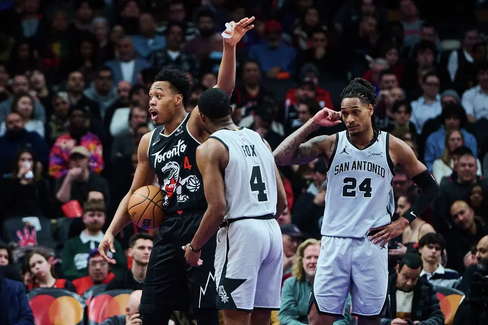 Toronto Raptors' Scottie Barnes, left, reacts to a foul call as San Antonio Spurs' De'Aaron Fox, center, and Devin Vassell (24) look on during the second half of an NBA basketball game in Toronto, on Wednesday, Feb. 25, 2026. (Sammy Kogan/The Canadian Press via AP)