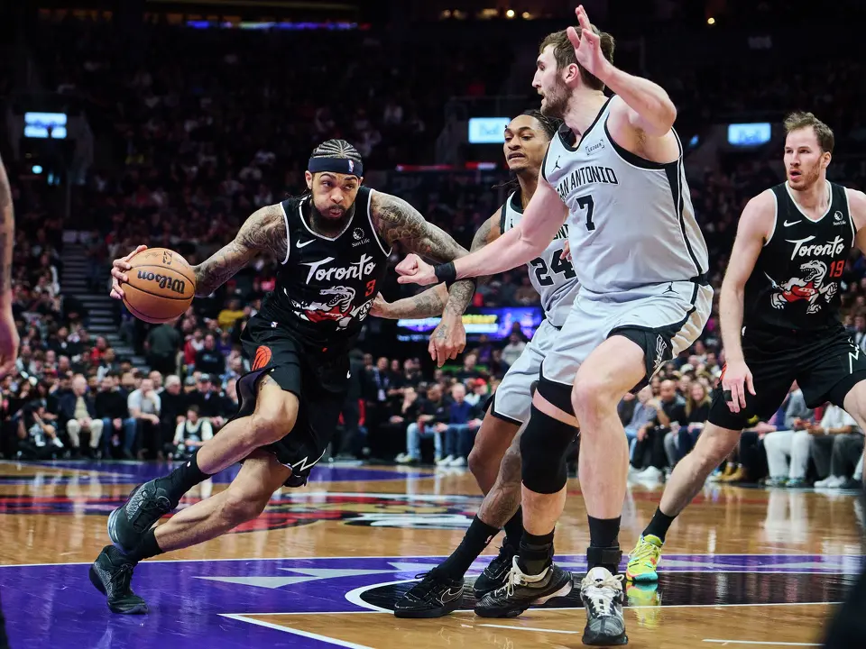 Toronto Raptors' Brandon Ingram (3) drives through San Antonio Spurs' Devin Vassell (24), centre, and Luke Kornet (7) during the first half of an NBA basketball game in Toronto, Wednesday, Feb. 25, 2026. (Sammy Kogan/The Canadian Press via AP)