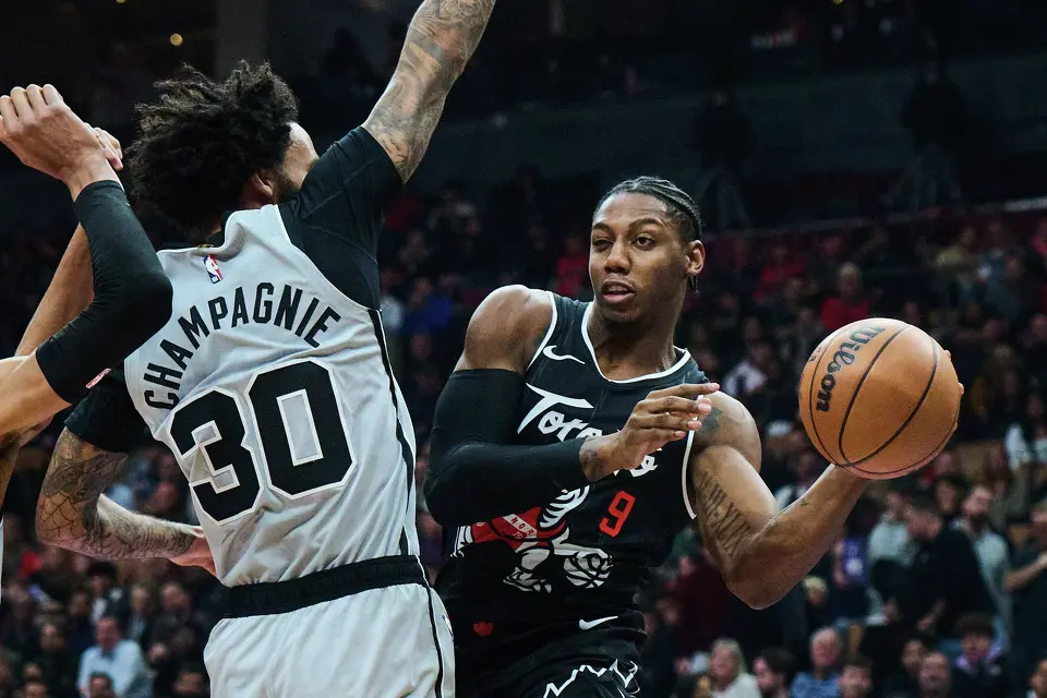 Toronto Raptors' RJ Barrett (9) lines up a pass around San Antonio Spurs' Julian Champagnie (30) during the first half of an NBA basketball game, in Toronto, Wednesday, Feb. 25, 2026. (Sammy Kogan/The Canadian Press via AP)