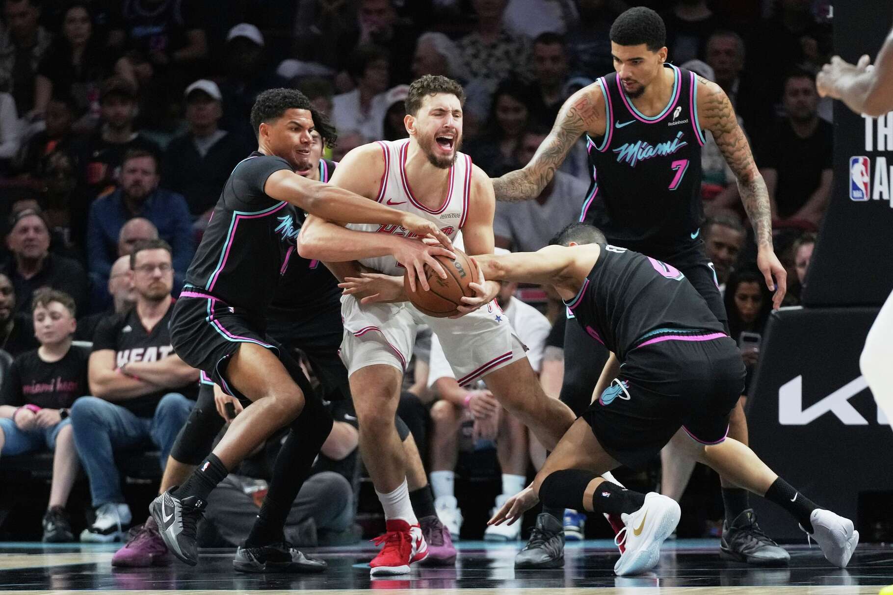 Miami Heat guard Dru Smith, left, and forward Simone Fontecchio, right, defend Houston Rockets center Alperen Sengun, center, during the first half of an NBA basketball game, Saturday, Feb. 28, 2026, in Miami. (AP Photo/Lynne Sladky)