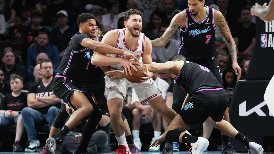 Miami Heat guard Dru Smith, left, and forward Simone Fontecchio, right, defend Houston Rockets center Alperen Sengun, center, during the first half of an NBA basketball game, Saturday, Feb. 28, 2026, in Miami. (AP Photo/Lynne Sladky)