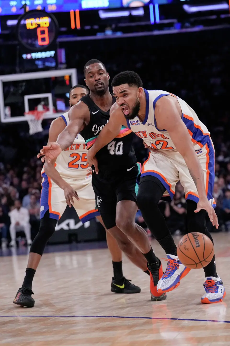 New York Knicks' Karl-Anthony Towns, right, drives to the basket during the first half of an NBA basketball game against the San Antonio Spurs Sunday, March 1, 2026, in New York. (AP Photo/Seth Wenig)