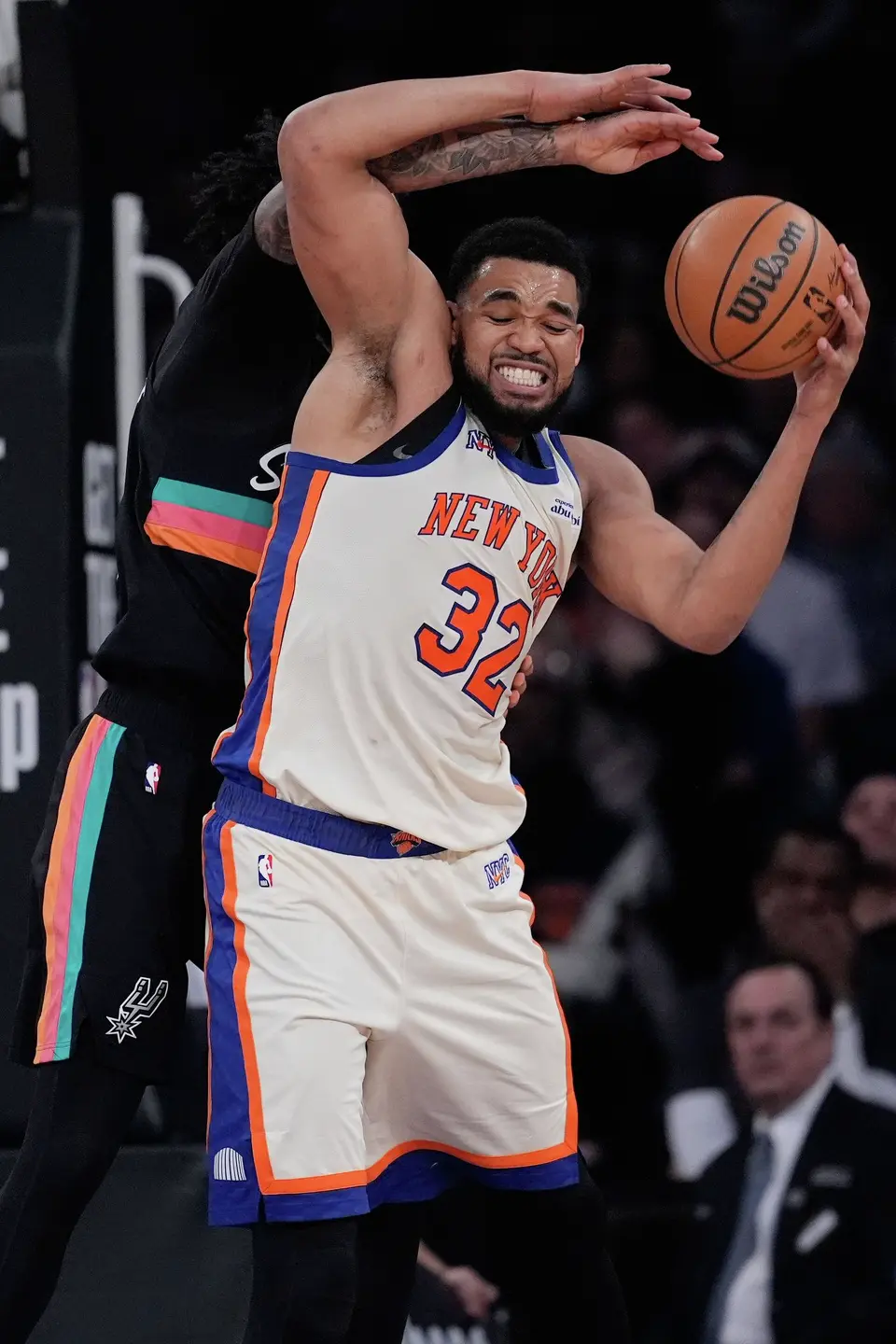New York Knicks' Karl-Anthony Towns (32) is fouled by San Antonio Spurs' Julian Champagnie during the second half of an NBA basketball game Sunday, March 1, 2026, in New York. (AP Photo/Seth Wenig)