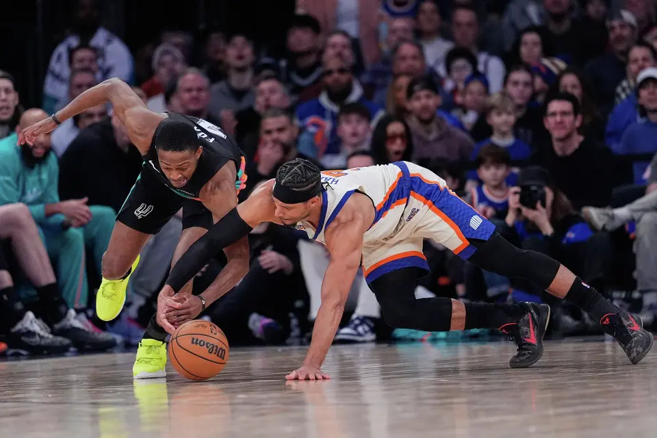 New York Knicks' Josh Hart, right, and San Antonio Spurs' De'Aaron Fox dive for a loose ball during the second half of an NBA basketball game Sunday, March 1, 2026, in New York. (AP Photo/Seth Wenig)