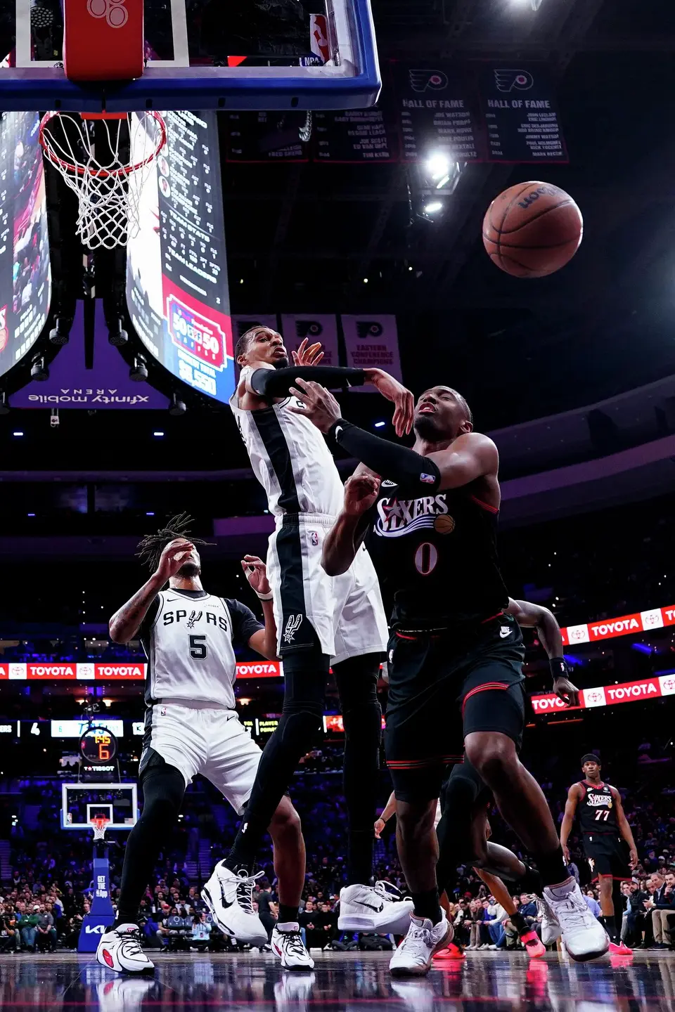 San Antonio Spurs' Victor Wembanyama, center, blocks the shot by Philadelphia 76ers' Tyrese Maxey, right, during the first half of an NBA basketball game, Tuesday, March 3, 2026, in Philadelphia. (AP Photo/Chris Szagola)