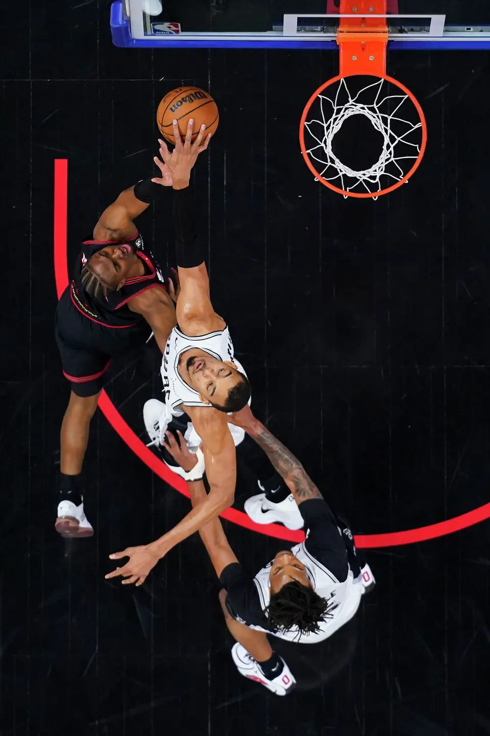 San Antonio Spurs' Victor Wembanyama, center, blocks the shot by Philadelphia 76ers' Tyrese Maxey, left, during the first half of an NBA basketball game, Tuesday, March 3, 2026, in Philadelphia. (AP Photo/Chris Szagola)