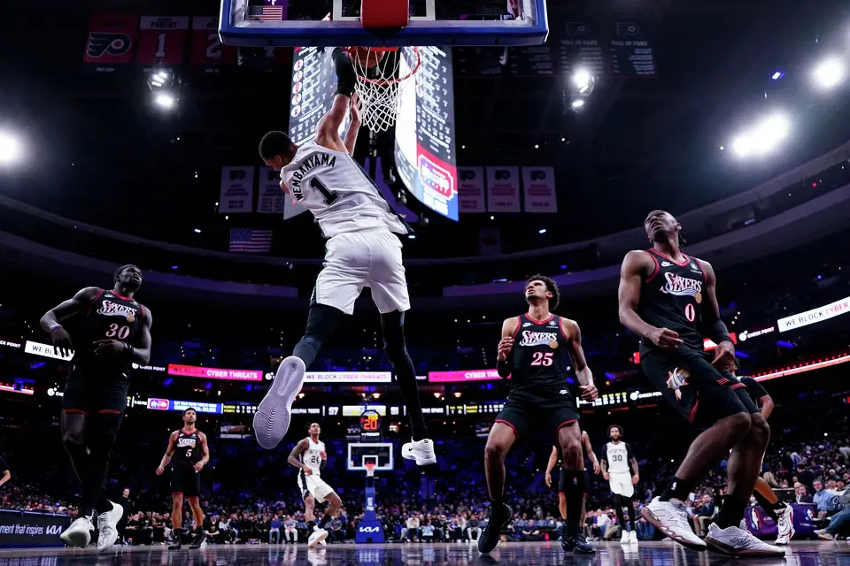 San Antonio Spurs' Victor Wembanyama, center left, dunks the ball as the Philadelphia 76ers look on during the second half of an NBA basketball game, Tuesday, March 3, 2026, in Philadelphia. (AP Photo/Chris Szagola)