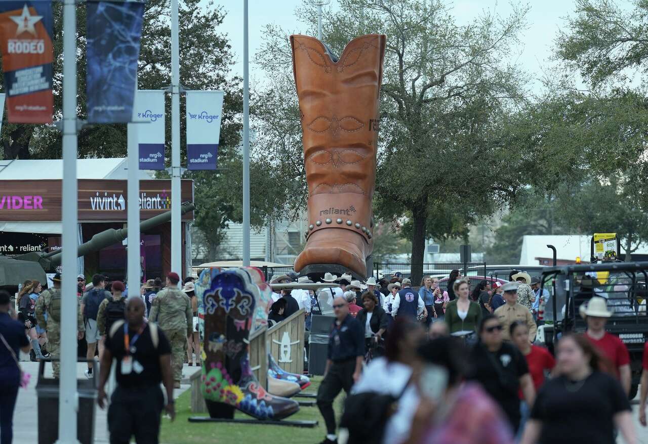 Attendees of the Houston Livestock and Rodeo walk by a large cowboy boot near NRG Stadium in Houston on Wednesday, March 4, 2026.