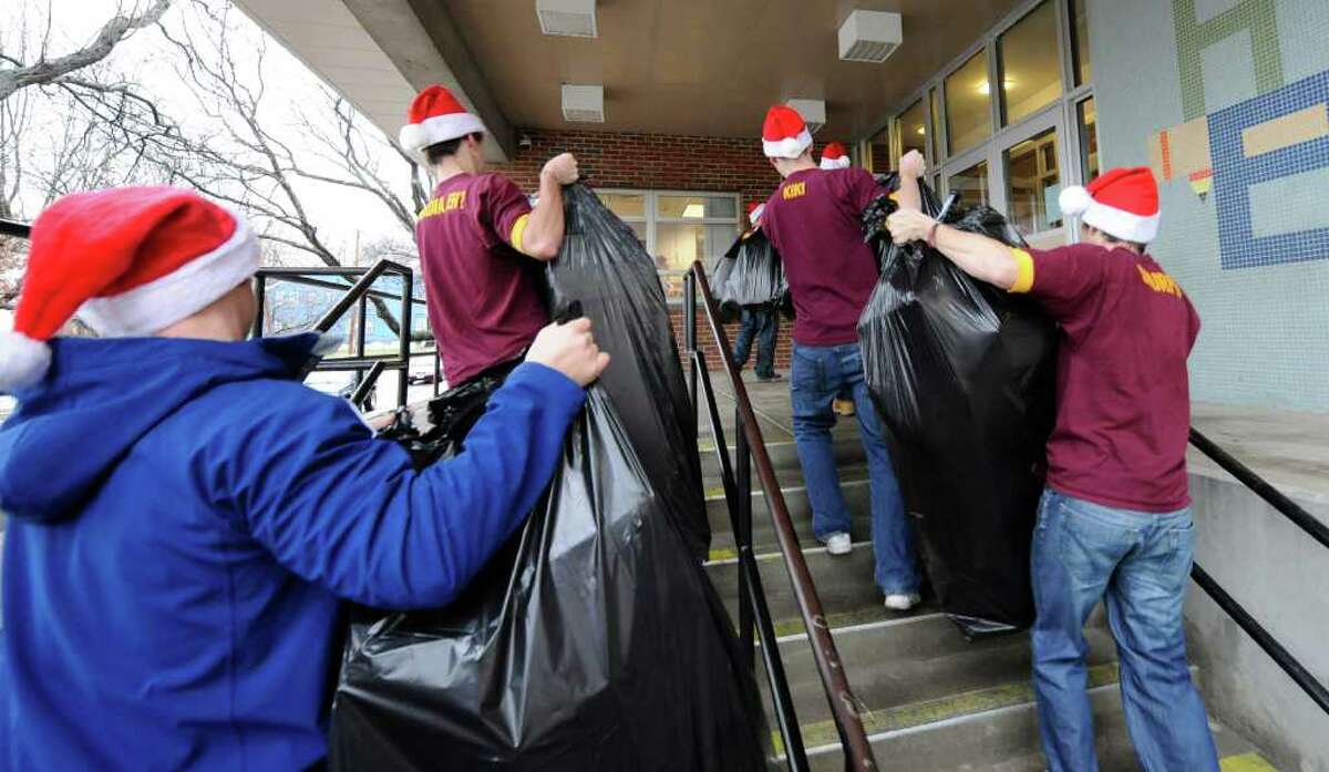 Members of the Pi Kappa Alpha fraternity from RPI take gifts to the students of Troy's Public School 2 on December 13, 2010. (Skip Dickstein / Times Union)