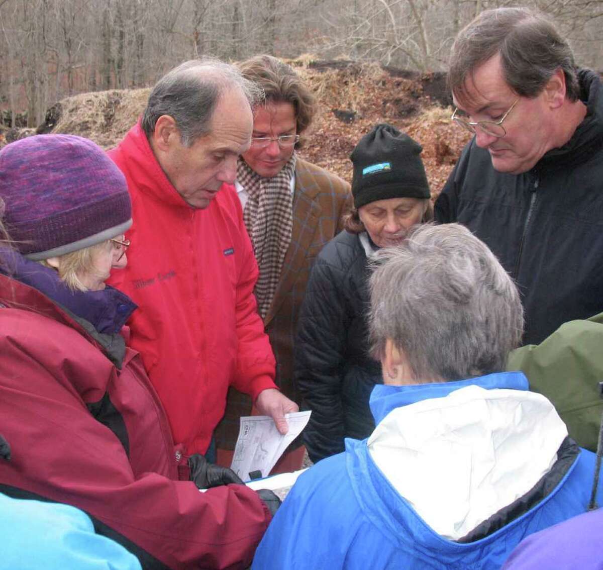 Conservation Commission Director Denise Savageau, at left, holds a map of the area where a cell tower may be placed at 129 Bible St., in the Montgomery Pinetum, on Monday. With her from left are Conservation Commission members Gary Silberberg, anti-cell tower activist Wayne Jervis, and commission members Lisette Henrey, Eric Brower and with back to camera, Sue Baker. (Photo by Frank MacEachern/staff)