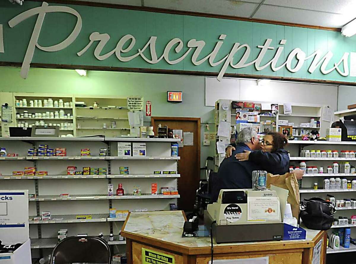 From left, Frank Renna, owner of Esquire Drugs, gets a farewell hug from regular customer Alexa Poli, of Menands, in Menands NY on December 13, 2010. (Lori Van Buren / Times Union)