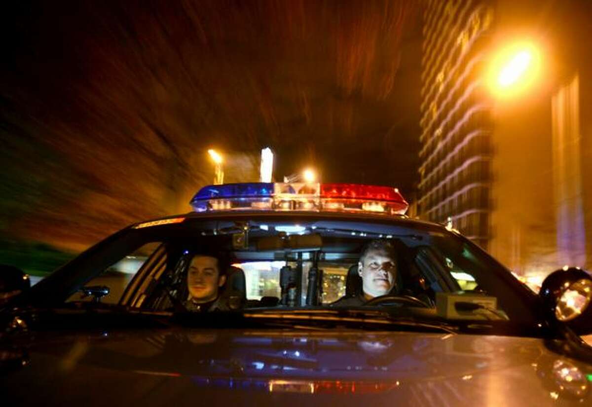 Seattle Police officer Chris Myers (right) drives a patrol car with officer Travis Hill in downtown Seattle in Oct. 2009. Meyers shot Jose Cardenas-Muratalla in Dec. 2010 and this week, the felon was convicted of unlawful firearm possession. Myers had previously been cleared and returned to patrol in the West Precinct.