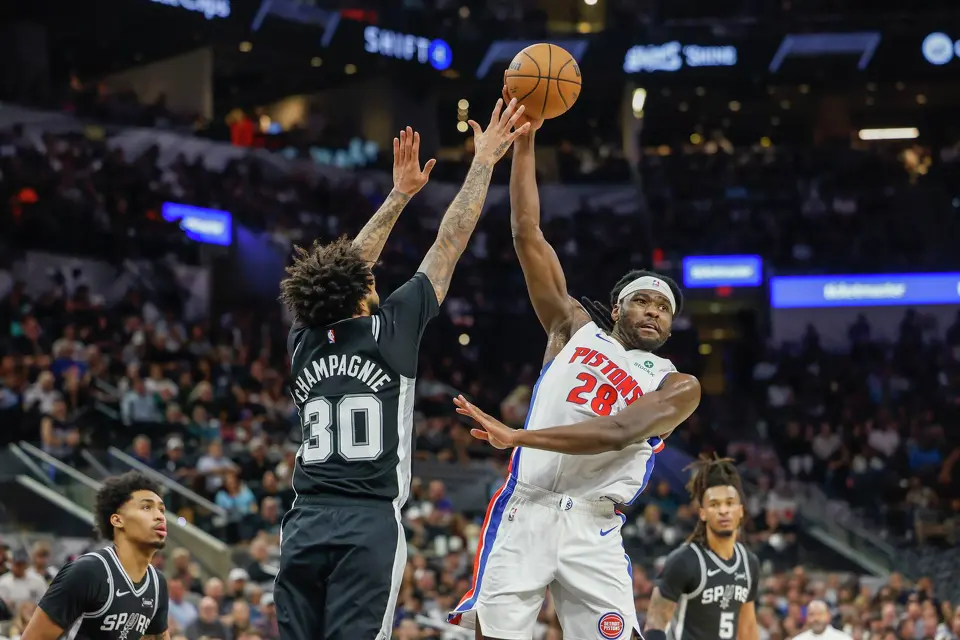 Detroit Pistons forward Isaiah Stewart (28) passes the ball guarded by San Antonio Spurs forward Julian Champagnie (30) at Frost Bank Center in San Antonio, Thursday, March 5, 2026. The Spurs defeated the Pistons, 121-106.