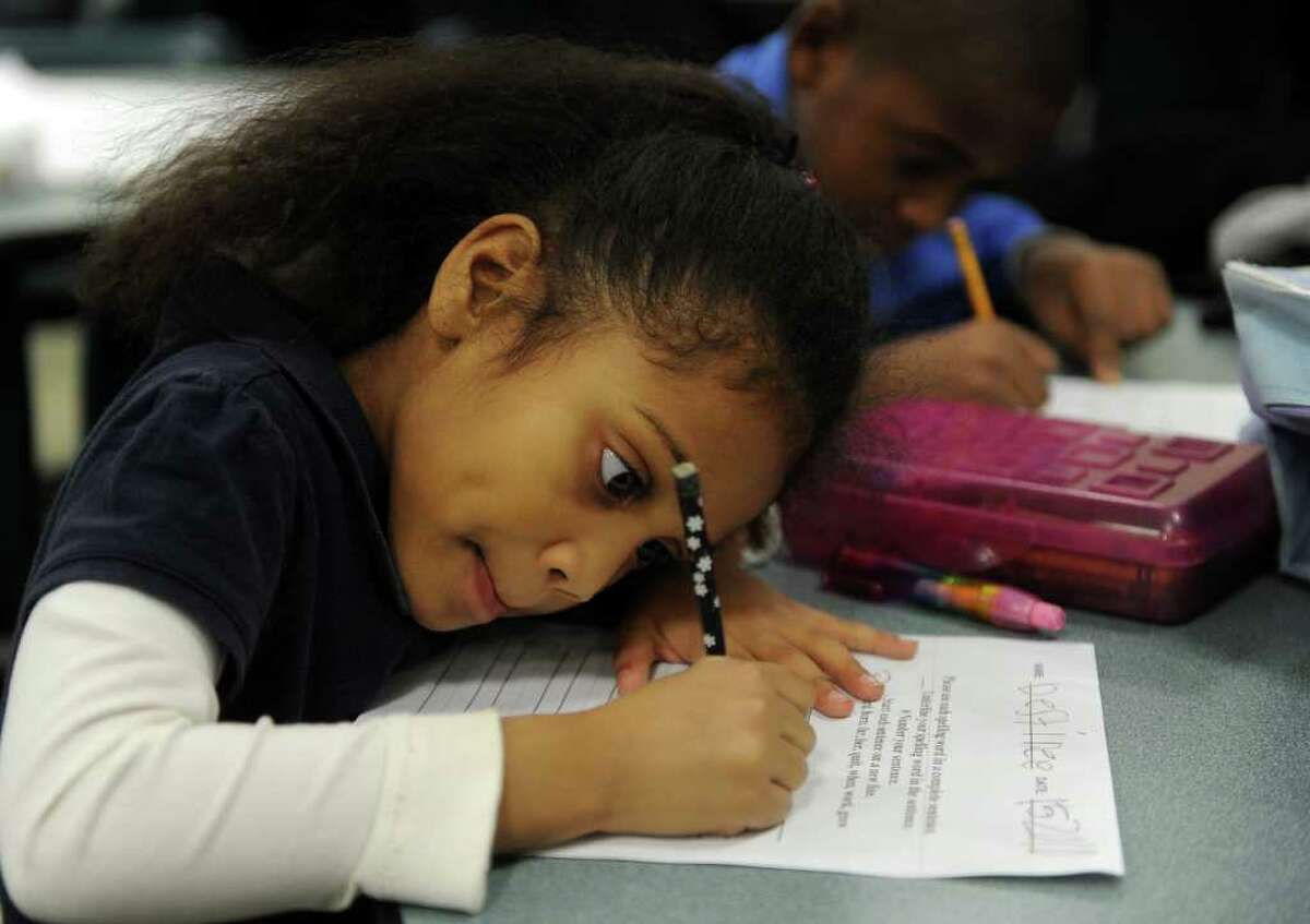 Destinee Mercer, 5, front, and Jerry Johnson, 8, back, work on their homework during Wednesday's Commpact meeting at Bassick High School on December 15, 2010.