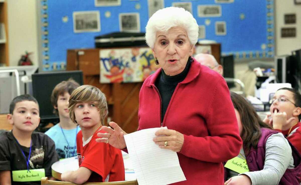 Kyle Burbank, left, and, Brennan Mayer, left center, are among fourth-graders at Hawley Elementry School in Newtown listening to Connie Scigimpaglia, 82, during a program called "Book Buddies" Thursday, Dec. 16, 2010.