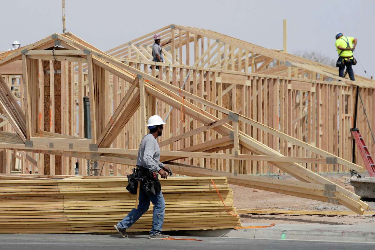 FILE - Construction workers install a lumber roof at a new home build Tuesday, April 1, 2025, in Laveen, Ariz.