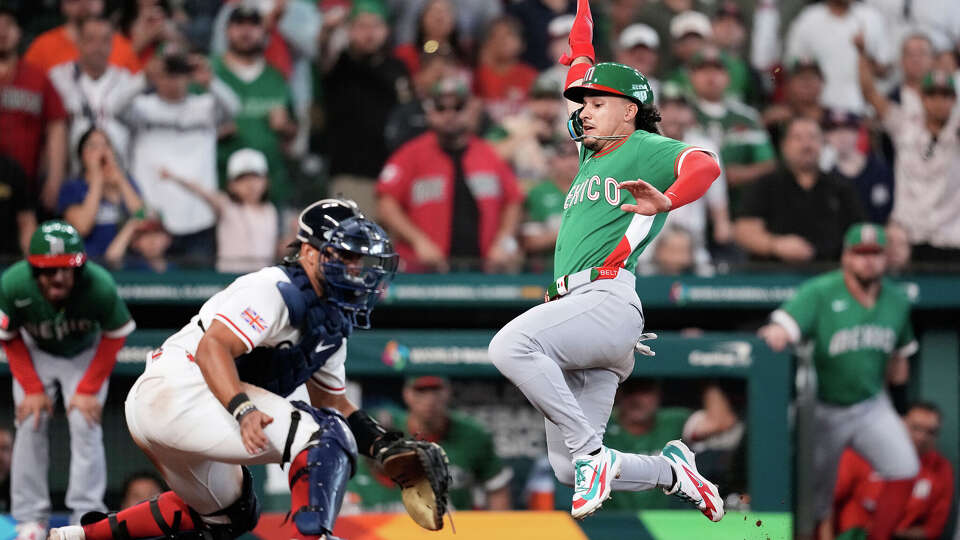 Mexico's Alek Thomas, right, slides home to score against Britain catcher Harry Ford during the ninth inning of a World Baseball Classic game, Friday, March 6, 2026, in Houston. (AP Photo/David J. Phillip)