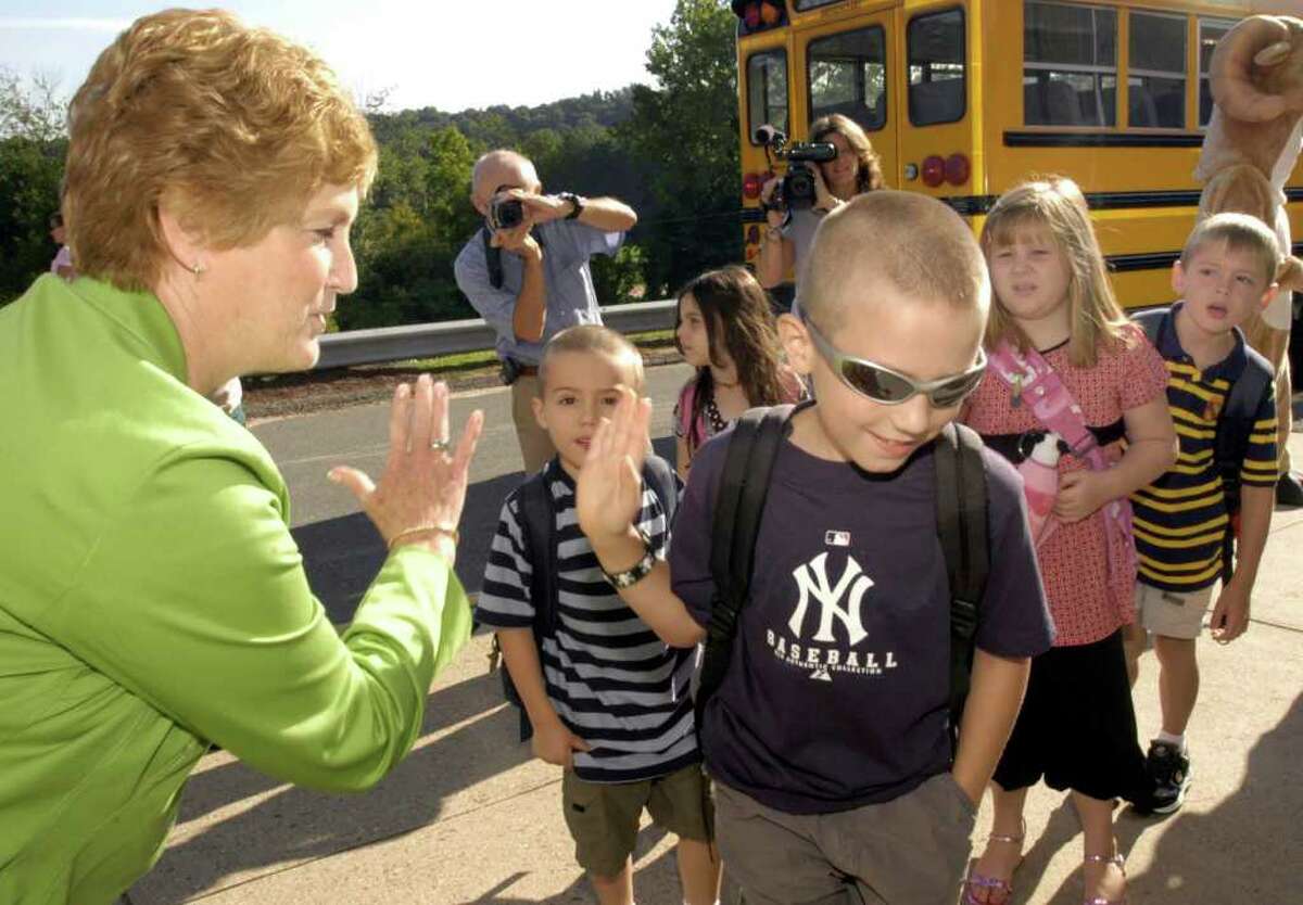 Governor M. Jodi Rell high-fives a fellow Yankees fan , Ben Webb, as he arrives at school for his first day of 5th grade. Gov. Rell was at Rockwell Elementary School Tuesday greeting children on the first day of school.