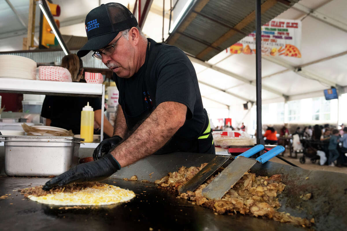 Ernesto Cardenas makes food from a large skillet at Texas Skillet during the Houston Livestock Show and Rodeo in Houston, Friday, March 6, 2026.