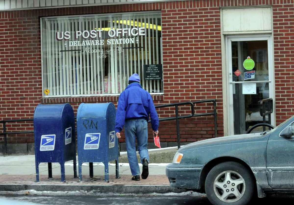 David H. Cohen, who grew up in Albany's Delaware Avenue neighborhood, mails a letter on Dec. 17 at the Delaware Station Post Office. (Cindy Schultz / Times Union)