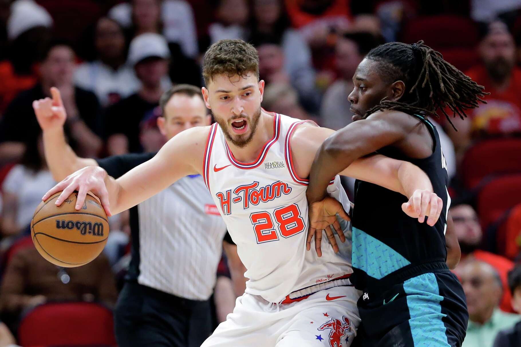 Houston Rockets center Alperen Sengun (28) drives into Portland Trail Blazers guard Jrue Holiday, right, during the first half of an NBA basketball game Friday March 6, 2026, in Houston. (AP Photo/Michael Wyke)