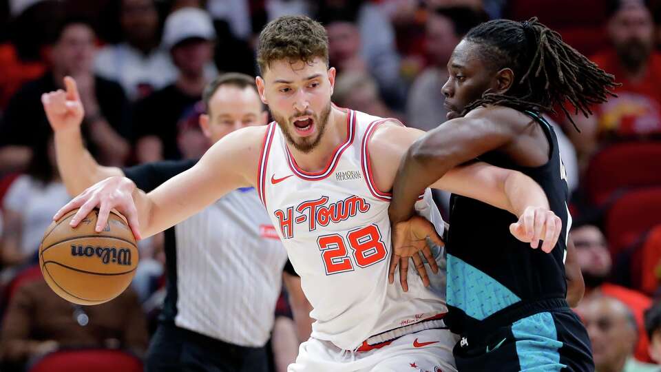 Houston Rockets center Alperen Sengun (28) drives into Portland Trail Blazers guard Jrue Holiday, right, during the first half of an NBA basketball game Friday March 6, 2026, in Houston. (AP Photo/Michael Wyke)
