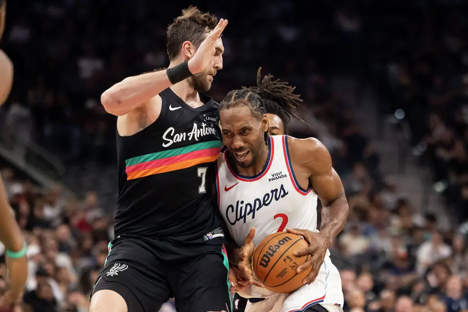 San Antonio Spurs center Luke Kornet (7) defends as LA Clippers forward Kawhi Leonard (2) carries the ball at Frost Bank Center in San Antonio on Friday, March 6, 2026. The Spurs defeated the Clippers 116-112.