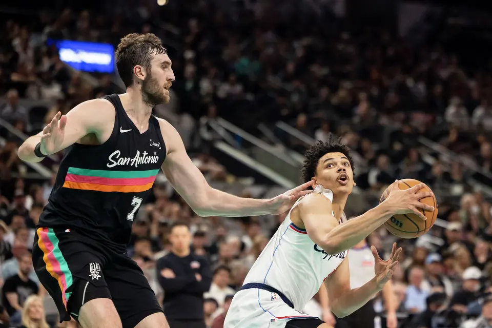 San Antonio Spurs center Luke Kornet (7) defends as LA Clippers guard Kobe Sanders (4) holds back the ball at Frost Bank Center in San Antonio on Friday, March 6, 2026. The Spurs defeated the Clippers 116-112.