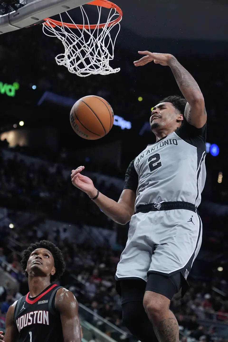 San Antonio Spurs guard Dylan Harper (2) scores over Houston Rockets guard Amen Thompson (1) during the first half of an NBA basketball game in San Antonio, Sunday, March 8, 2026. (AP Photo/Eric Gay)
