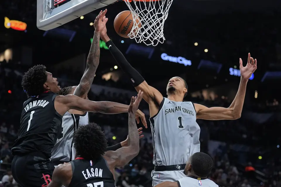 Houston Rockets guard Amen Thompson, left, and San Antonio Spurs forward Victor Wembanyama, right, reach for a refund during the second half of an NBA basketball game in San Antonio, Sunday, March 8, 2026. (AP Photo/Eric Gay)