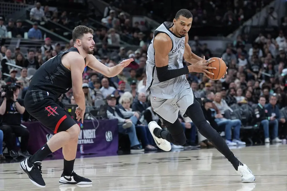 San Antonio Spurs forward Victor Wembanyama (1) drives around Houston Rockets center Alperen Sengun (28) during the first half of an NBA basketball game in San Antonio, Sunday, March 8, 2026. (AP Photo/Eric Gay)