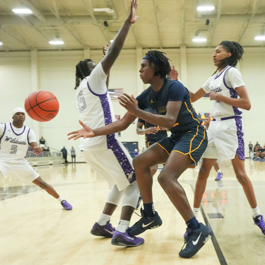 La Marque's Brandan Harris (22) dishes the ball around Wheatley's defense during the boys high School Class 4A Division II state semifinals at Hopson Fieldhouse in Missouri City on Tuesday, March 10, 2026. La Marque won the game 68-67.