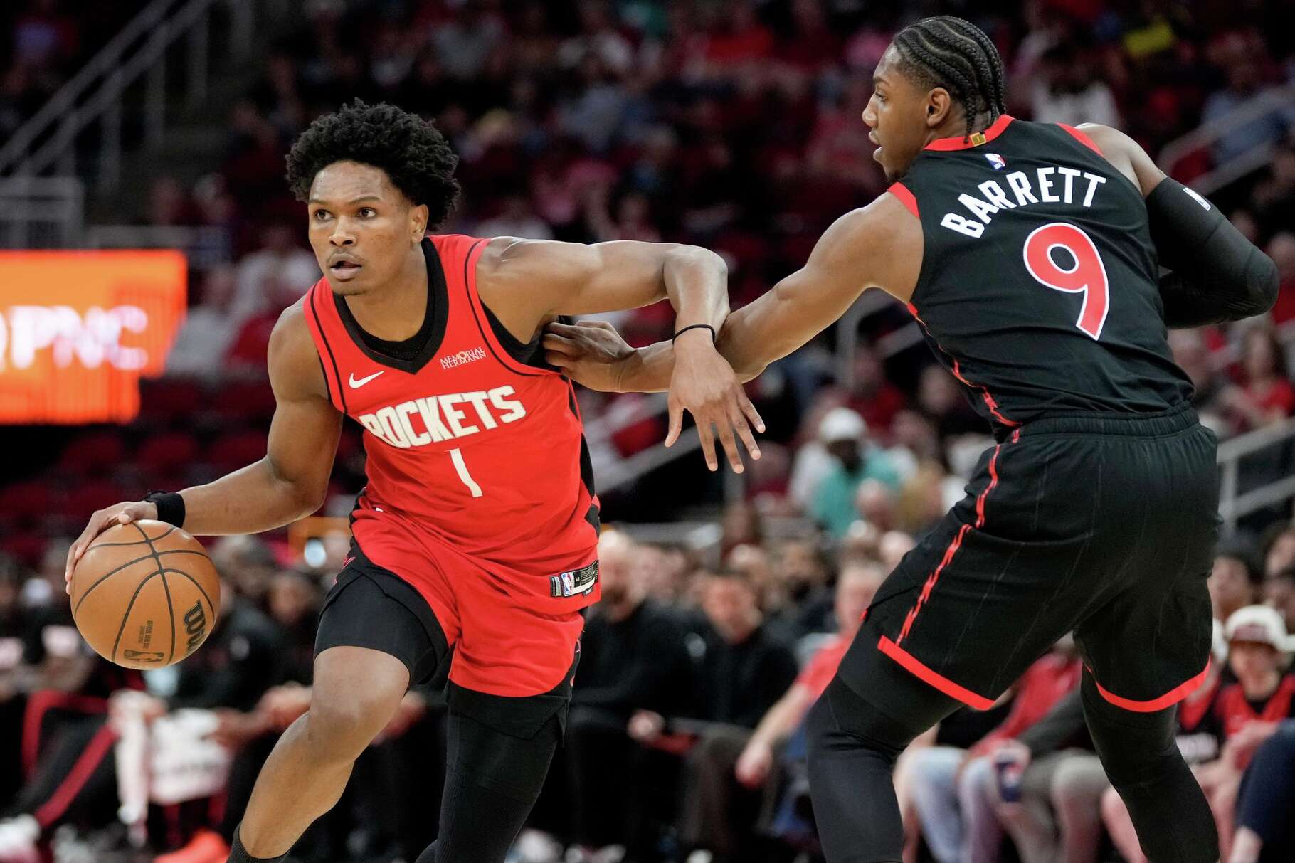 Houston Rockets guard Amen Thompson (1) dribbles as Toronto Raptors forward RJ Barrett defends during the first half of an NBA basketball game Tuesday, March 10, 2026, in Houston. (AP Photo/Eric Christian Smith)